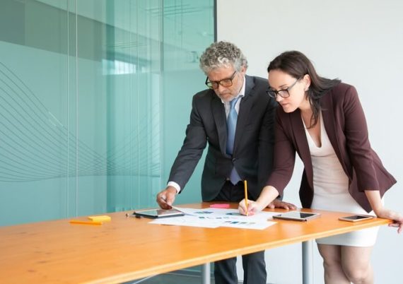 focused-businesspeople-watching-statistics-documents-making-notes_74855-9897 (1)